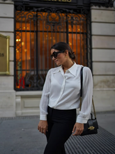A woman wears acetate pleated shirt